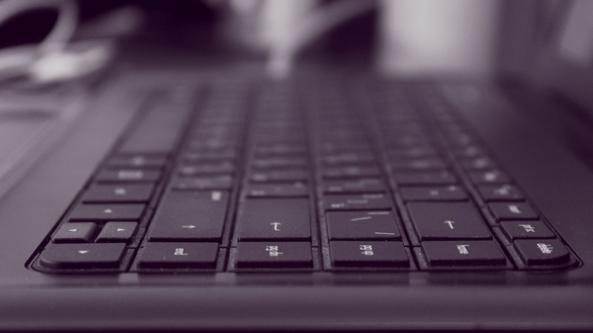 Close-up de mãos digitando em um teclado moderno para automação de documentos.