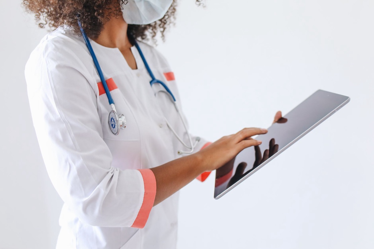 Arzt prüft Smartphone-Schirm mit Gesundheitsdaten