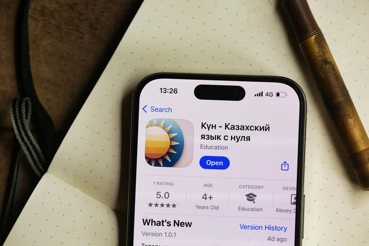 智慧型手機顯示出哈薩克語學習應用程式，周圍是舒適的環境。